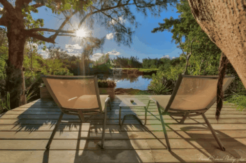 Terrasse der Bubble Lodge Ile aux Cerfs mit Liegestühlen und Blick auf das Wasser