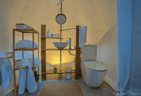 Badezimmer der Bubble Lodge Ile aux Cerfs mit Waschbecken, WC und hellen Handtüchern