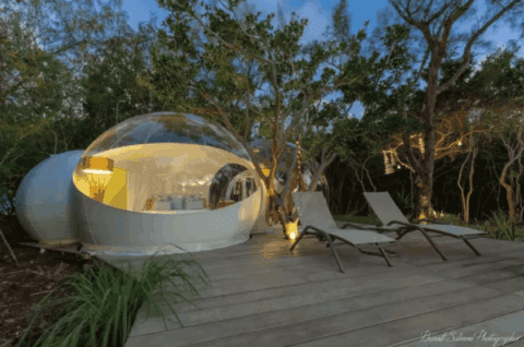 Bubble Lodge Ile aux Cerfs bei Abendlicht mit Liegestühlen auf der Holzterrasse