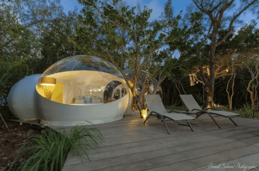 Bubble Lodge Ile aux Cerfs bei Abendlicht mit Liegestühlen auf der Holzterrasse