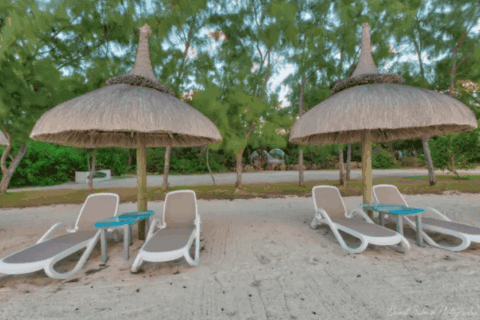 Strandbereich der Bubble Lodge Ile aux Cerfs mit Liegen und Sonnenschirmen