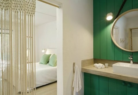 Badezimmer im Coin de Mire Attitude mit grünem Waschtisch und Blick ins Schlafzimmer