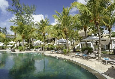 Poolbereich im Coin de Mire Attitude mit Sonnenliegen, Palmen und Hotelgebäuden