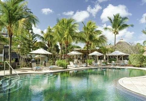 Tropischer Pool im Coin de Mire Attitude mit Liegen, Sonnenschirmen und Palmen