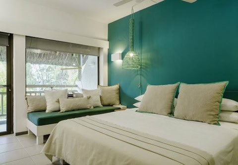 Modernes Hotelzimmer im Coin de Mire Attitude mit türkisfarbener Wand und Sitzbank