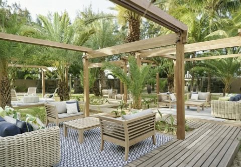 Tropische Lounge-Terrasse im Coin de Mire Attitude mit Rattanmöbeln und Palmen