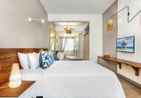Doppelzimmer im Friday Attitude mit weißem Bett, Holzkopfteil und TV