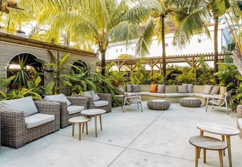 Tropischer Innenhof im Friday Attitude mit gemütlichen Sitzgelegenheiten unter Palmen