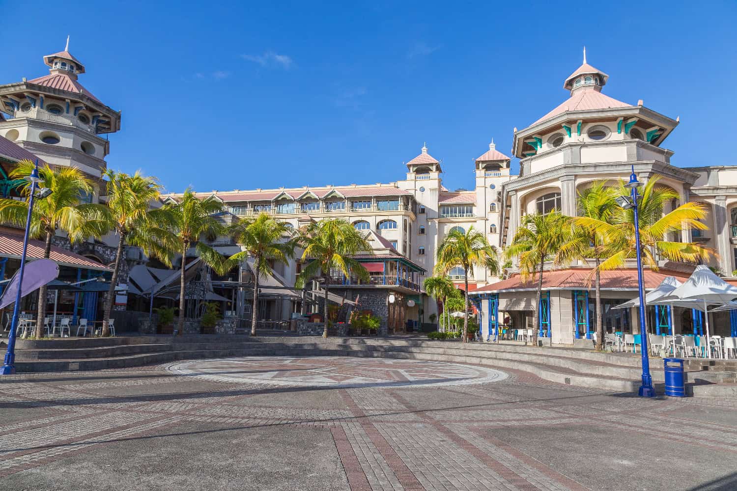 Blick auf die Caudan Waterfront in Port Louis mit Palmen, Kolonialarchitektur und blauem Himmel auf Mauritius
