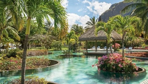 Tropischer Poolbereich im LUX Le Morne mit Palmen und Blick auf den Berg Le Morne