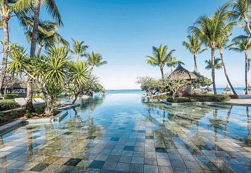 Poolanlage im La Pirogue Mauritius mit Palmen und Blick aufs Meer
