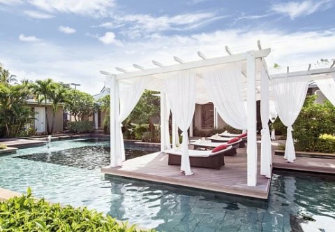 Sonnendeck am Pool im La Pirogue Mauritius mit weißen Vorhängen