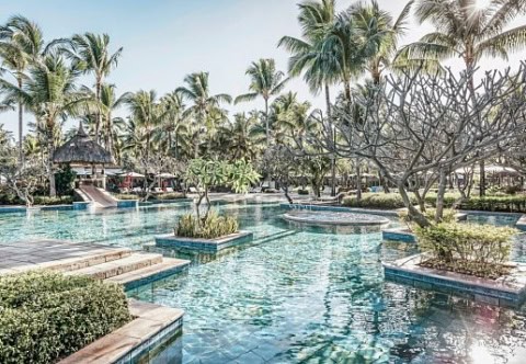 Resort-Pool mit Insel-Plattformen, Vegetation und Palmen