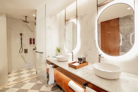 Helles Badezimmer im Le Meridien Ile Maurice mit Doppelwaschtisch und Marmordesign