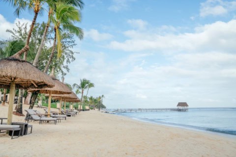 Sandstrand des Le Meridien Ile Maurice mit Liegen, Sonnenschirmen und Steg ins Meer