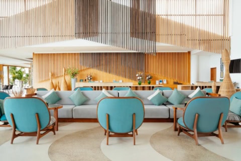 Lobby im Le Meridien Ile Maurice mit türkisfarbenen Sesseln und hellem Empfangsbereich
