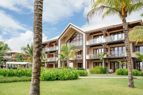 Hotelgebäude des Le Meridien Ile Maurice mit Balkonen, Palmen und tropischem Garten