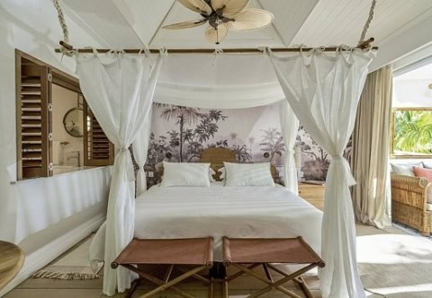 Helles Schlafzimmer mit Himmelbett im Paradise Cove Boutique Hotel