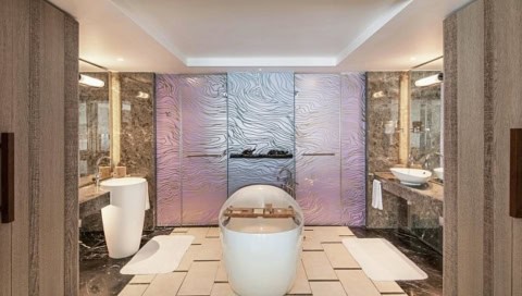 Luxuriöses Badezimmer im Shangri-La Le Touessrok mit freistehender Badewanne und edler Steinoptik