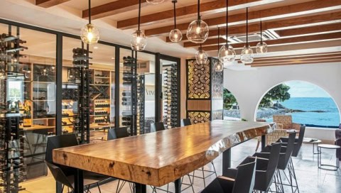 Weinkeller im Shangri-La Le Touessrok mit langem Holztisch und Meerblick