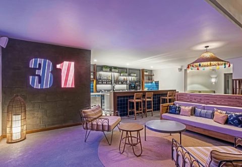 Barbereich im Sunrise Attitude Belle Mare mit Lounge-Sesseln und farbigem Licht