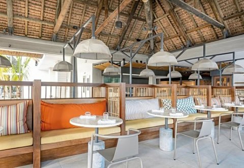 Restaurant im Sunrise Attitude Belle Mare mit Holzbänken und Strohdach