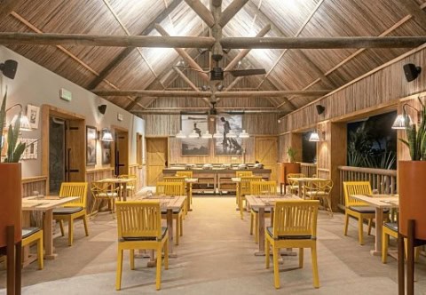 Innenrestaurant im Sunrise Attitude Belle Mare mit gelben Stühlen und Holzdach
